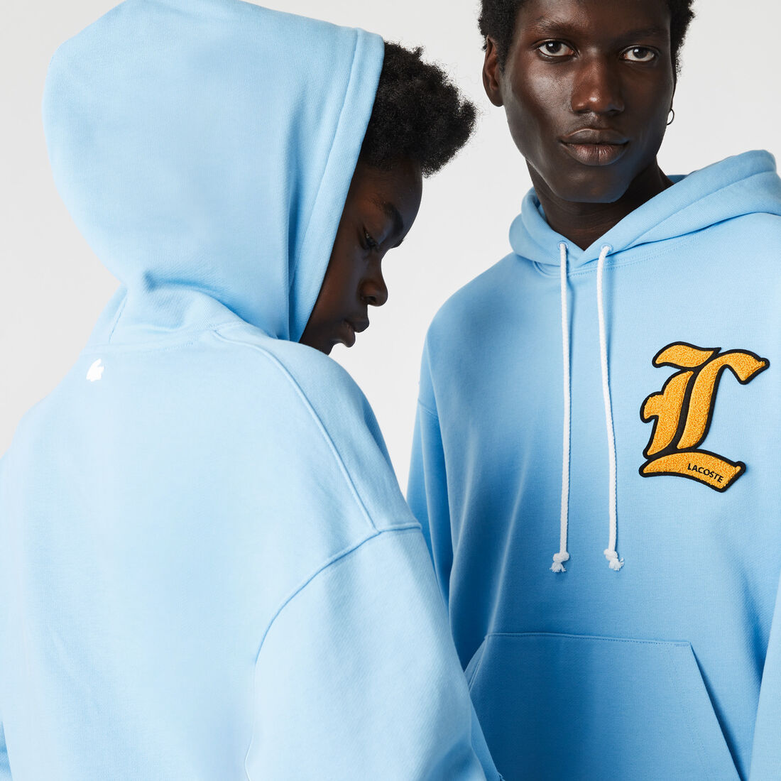 كنزة فضفاضة بغطاء للرأس للجنسين من مجموعة Lacoste L!VE