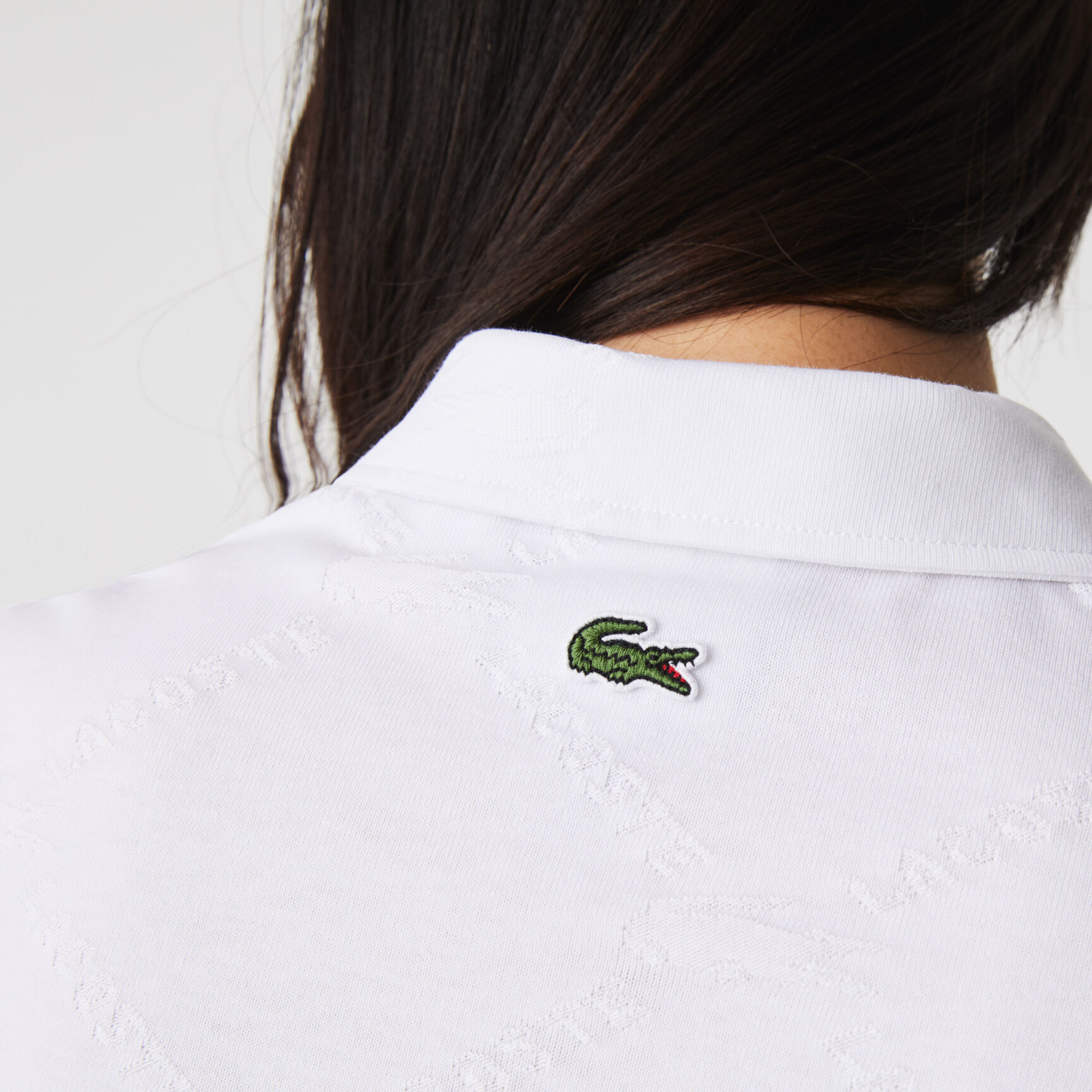 قميص بولو بأنماط مونوغرام وقصة ضيقة مجموعة Lacoste LIVE للنساء